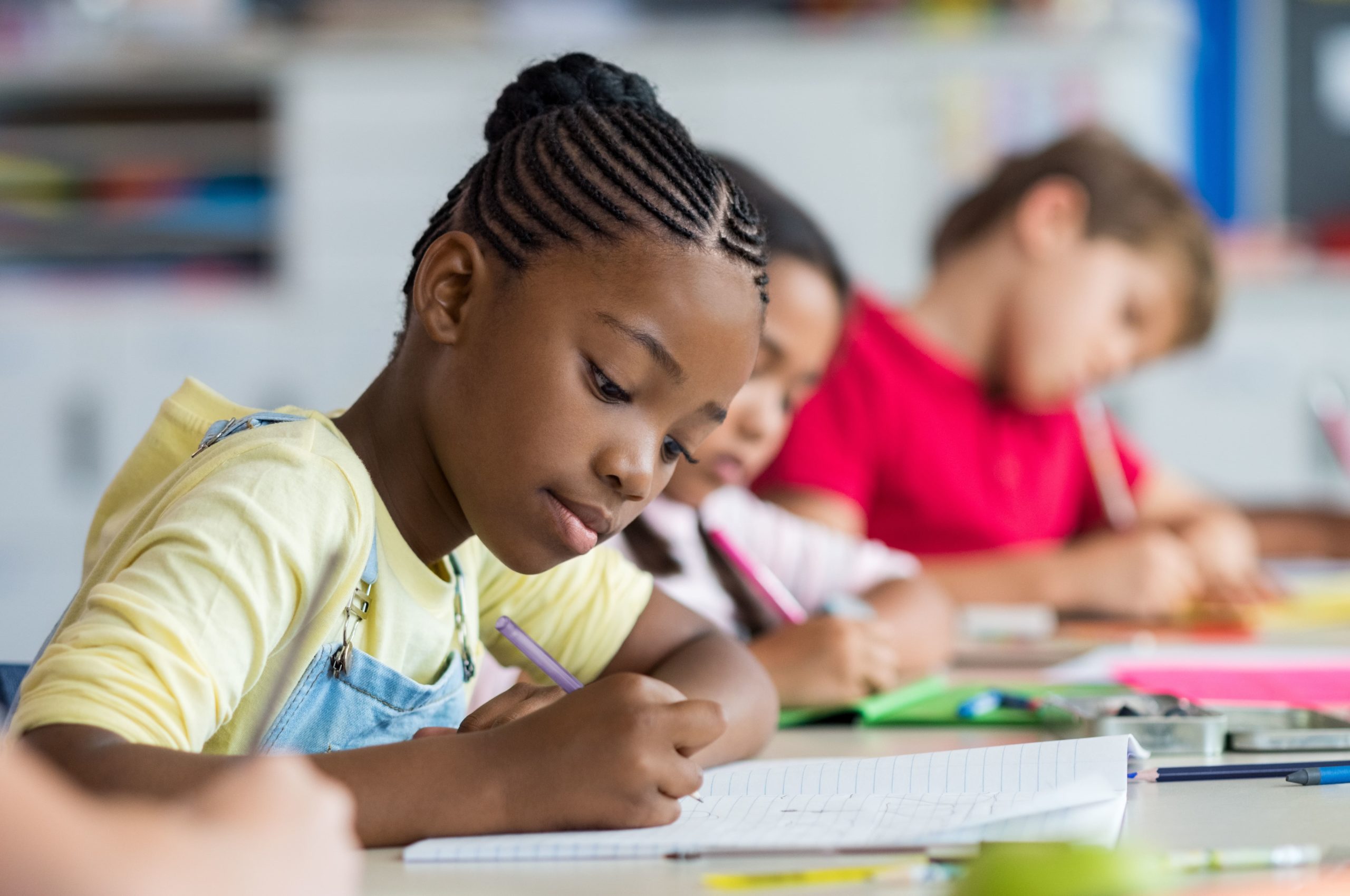 young black girl focused on writing assignment